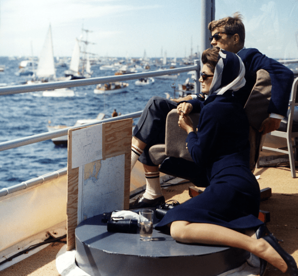 Watching the America's Cup Race. Mrs. Kennedy, President Kennedy, others. Off Newport, RI, aboard the USS Joseph P. Kennedy, Jr. by Robert Knudsen