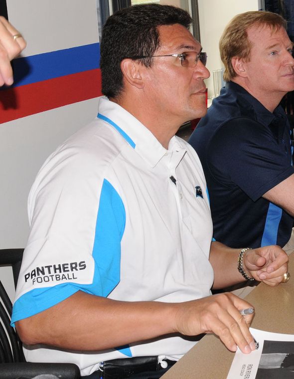Photo Credit: Reginald RogersParaglide Carolina Panther head coach Ron Rivera, left, NFL Commissioner Roger Goodell and former Carolina Panthers player Mike Rucker sign autographs and photos for Soldiers at the 1st Brigade Combat Team dining facility Friday during their visit to the post.