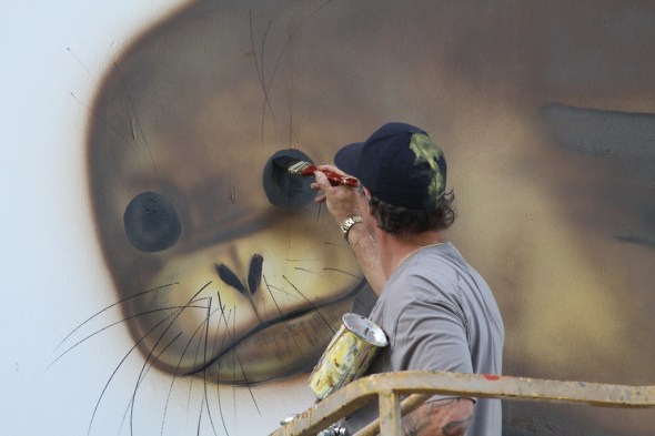 The artist Wyland, who goes by only one name, paints a mural on Charlie Barracks, a former military barracks still in use on Midway. Midway Atoll National Wildlife Refuge, Papahānaumokuākea Marine National Monument January 2012 Photo: Pete Leary/USFWS